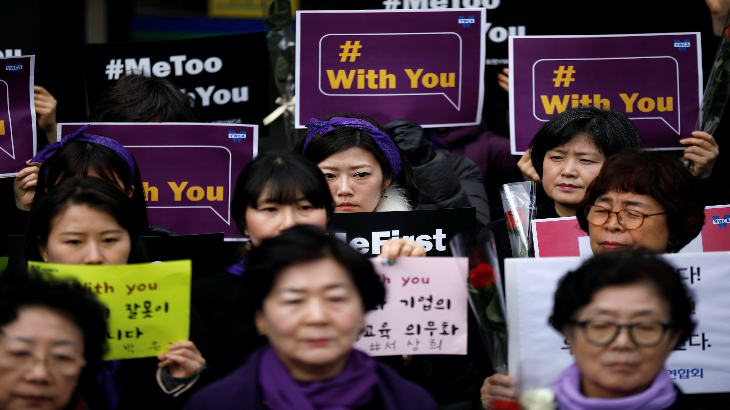 A crowd of South Korean women holding protest signs. The signs say 'Me Too' and 'With You'.