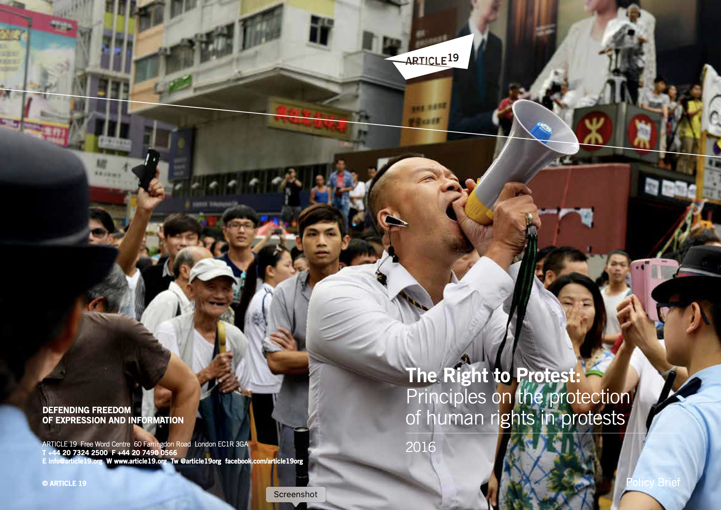 Front cover of ARTICLE 19's publication 'The Right to Protest'. It depicts a crowd of people at a street protest. The man in the foreground is shouting through a loudspeaer.