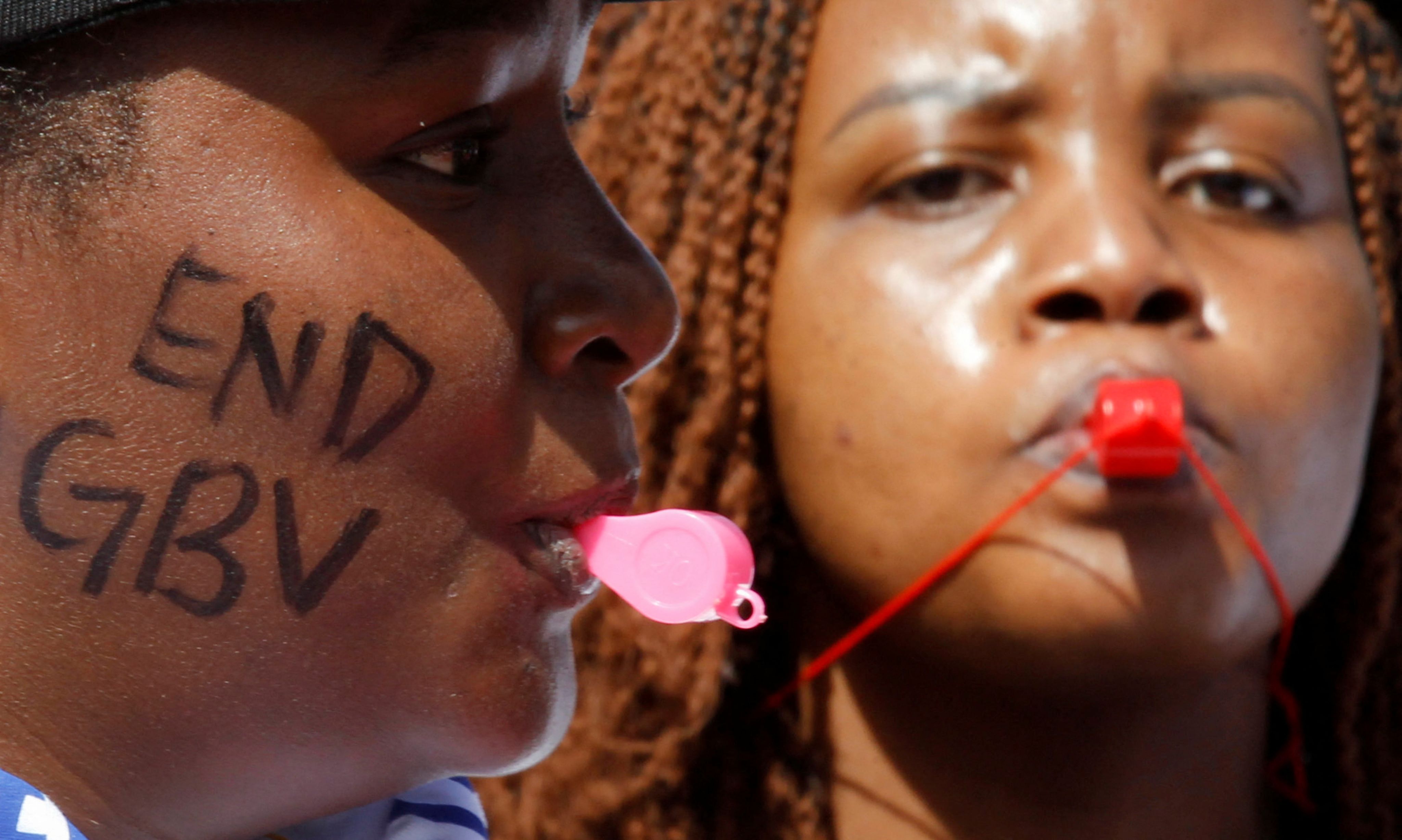 Women and civil society activists blow whistles as they demonstrate against gender-based violence.